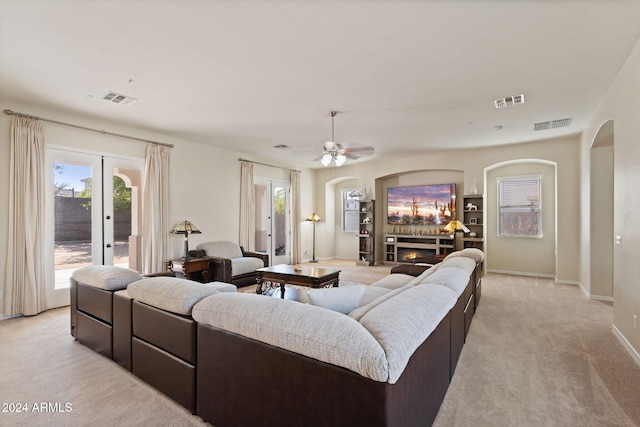 carpeted living room with french doors and ceiling fan