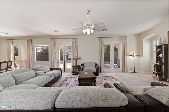 living room featuring french doors, ceiling fan, light carpet, and plenty of natural light