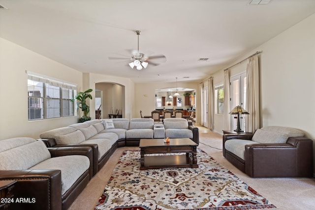 carpeted living room featuring ceiling fan and plenty of natural light