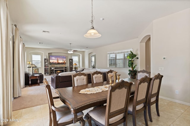 tiled dining area with plenty of natural light and ceiling fan