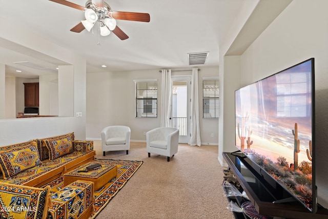 living room featuring light colored carpet and ceiling fan