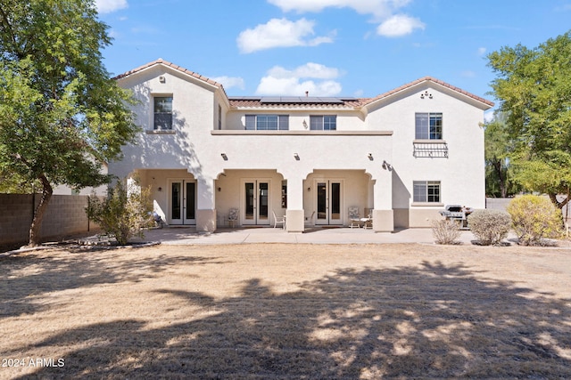 rear view of house with a patio area and solar panels