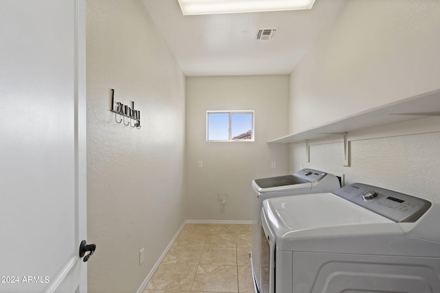 washroom with washing machine and dryer and light tile patterned floors