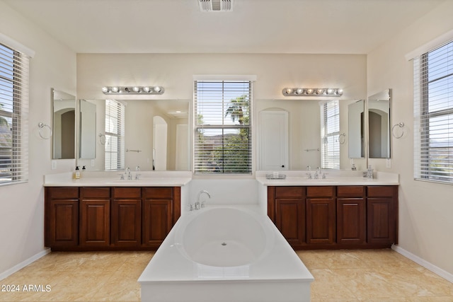 bathroom featuring vanity, a tub to relax in, and tile patterned floors