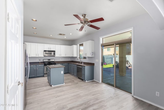 kitchen featuring gray cabinetry, a kitchen island, white cabinetry, appliances with stainless steel finishes, and light hardwood / wood-style floors