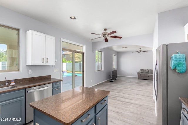 kitchen featuring blue cabinetry, ceiling fan, white cabinetry, light wood-type flooring, and appliances with stainless steel finishes