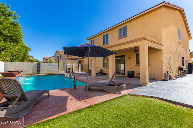 view of pool featuring a patio, a lawn, ceiling fan, and pool water feature