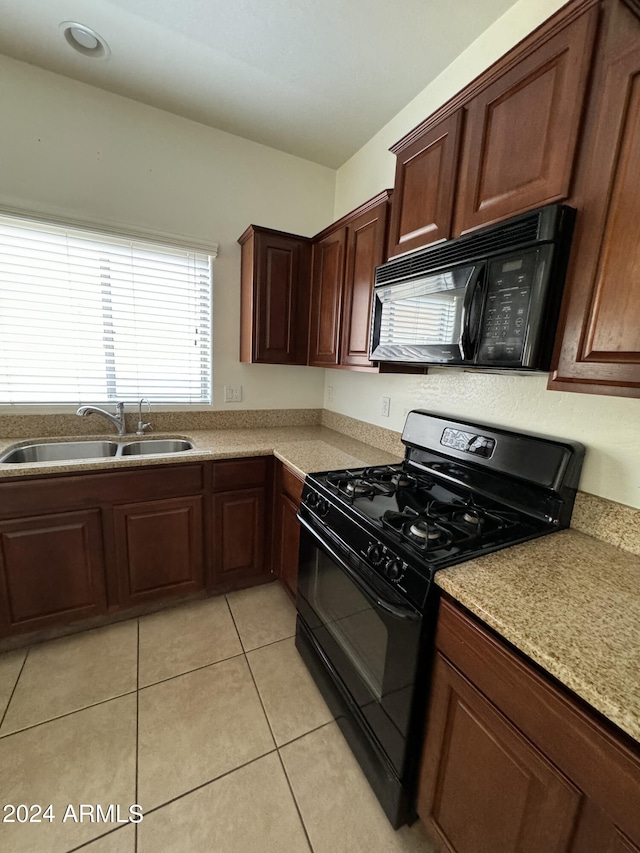 kitchen with black appliances, sink, and light tile patterned floors