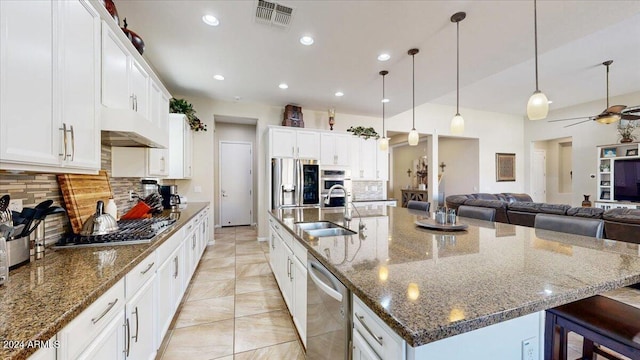 kitchen featuring white cabinets, sink, decorative backsplash, a large island, and stainless steel appliances