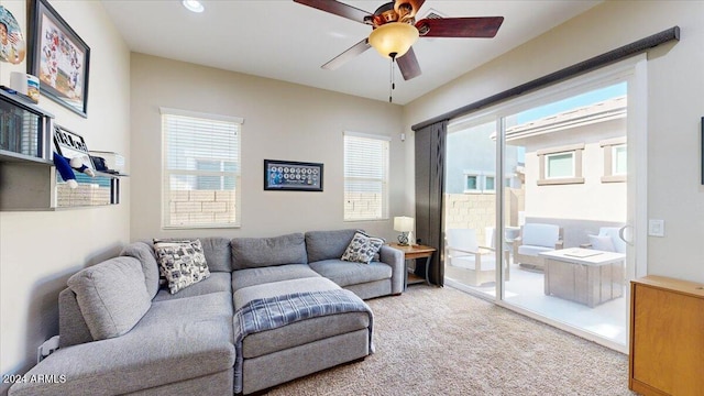 living room with light carpet, ceiling fan, and a healthy amount of sunlight