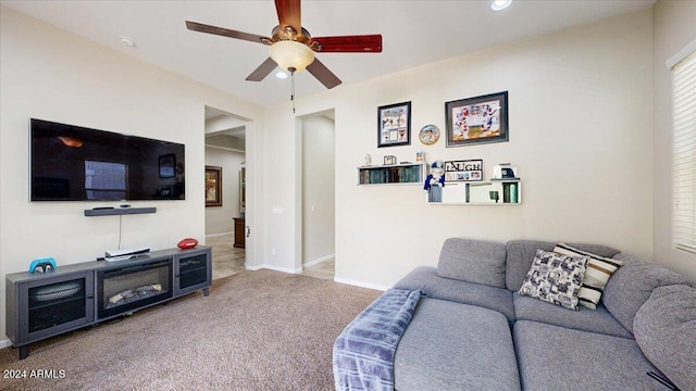 carpeted living room with ceiling fan