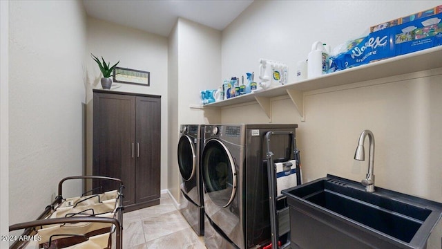 clothes washing area with washing machine and dryer and sink