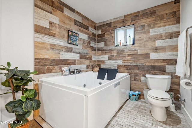 bathroom with wooden walls, toilet, and a bath