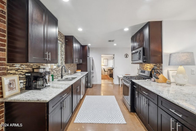 kitchen with stainless steel appliances, light stone countertops, decorative backsplash, and sink