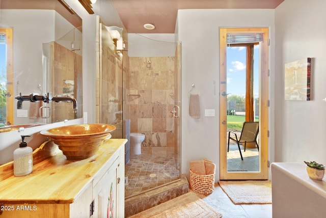 bathroom with tile patterned floors, an enclosed shower, vanity, and toilet