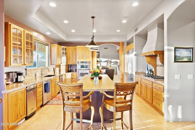 kitchen featuring wall chimney exhaust hood, hanging light fixtures, stainless steel appliances, light tile patterned floors, and backsplash