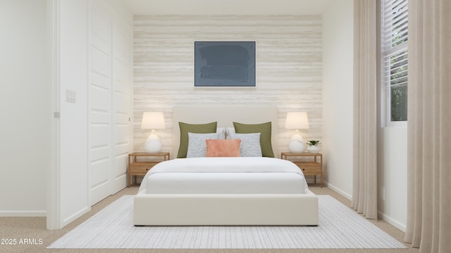 carpeted bedroom featuring baseboards and an accent wall