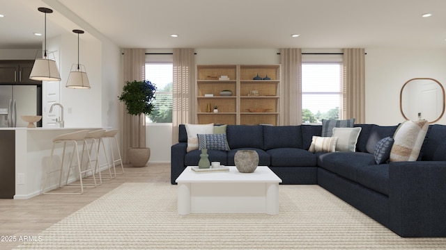 living area with recessed lighting, baseboards, and light wood finished floors