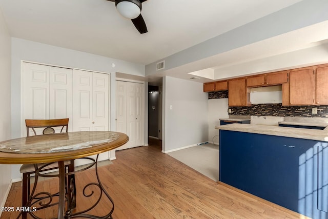 kitchen featuring wood-type flooring, backsplash, and ceiling fan