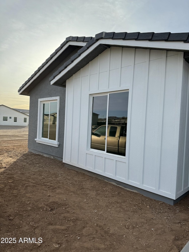 property exterior at dusk featuring board and batten siding