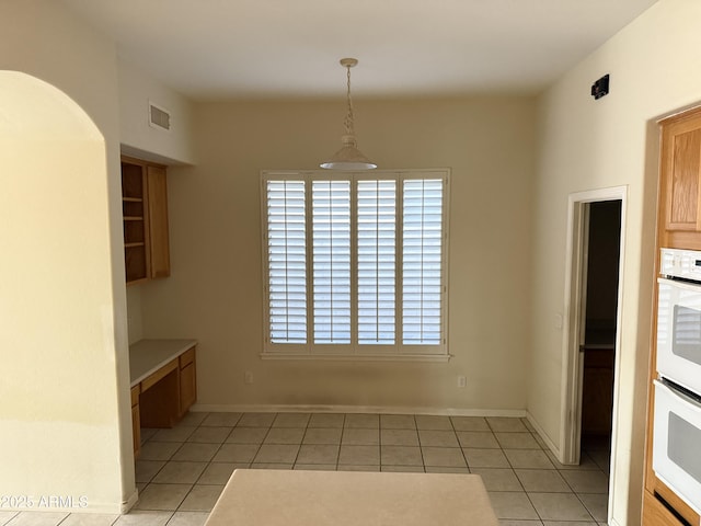 unfurnished dining area with light tile patterned flooring