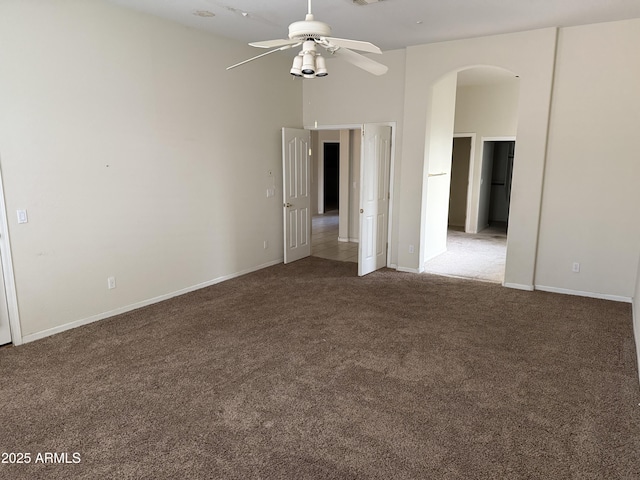 unfurnished room with ceiling fan and dark colored carpet