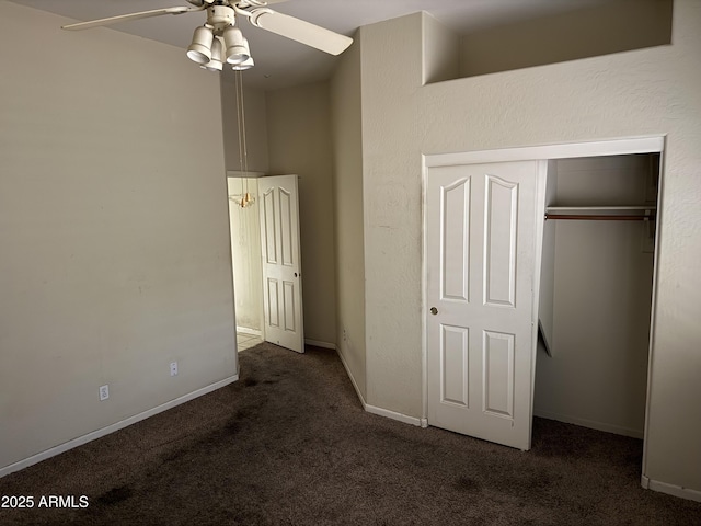 unfurnished bedroom with a closet, ceiling fan, and dark colored carpet