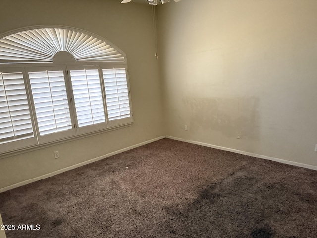 carpeted spare room featuring ceiling fan