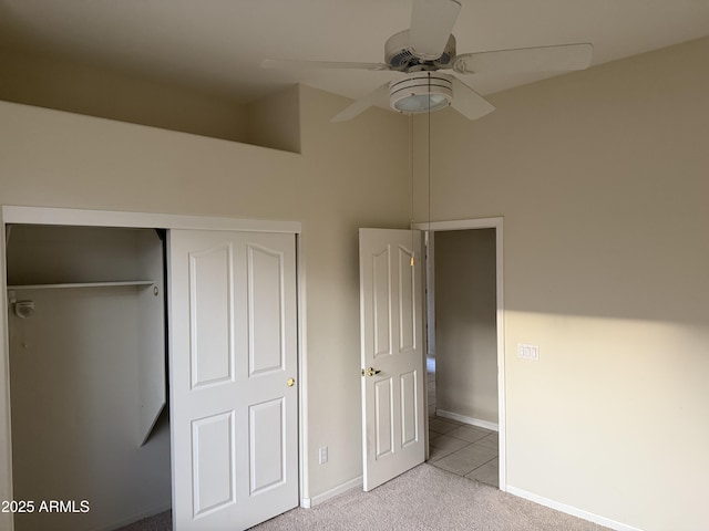 unfurnished bedroom featuring light carpet, ceiling fan, and a closet