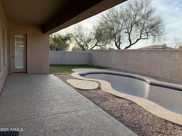 pool at dusk featuring a patio area