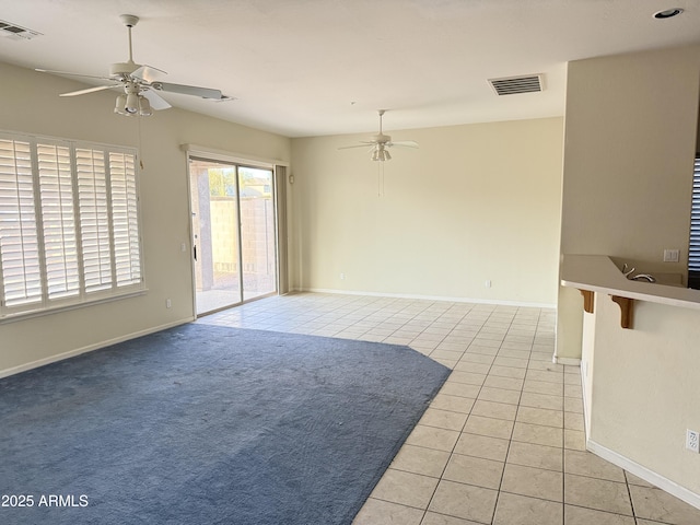 tiled spare room featuring ceiling fan