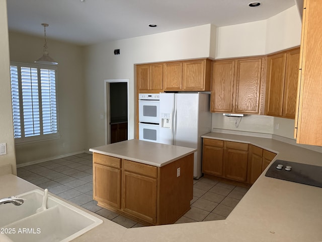 kitchen featuring white appliances, decorative light fixtures, sink, and light tile patterned floors