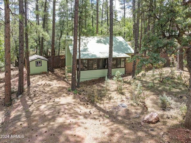 exterior space with an outbuilding, metal roof, and a storage unit