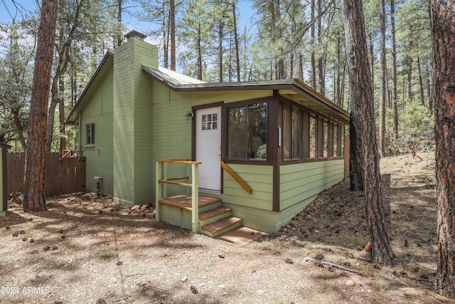 view of outbuilding with entry steps and fence