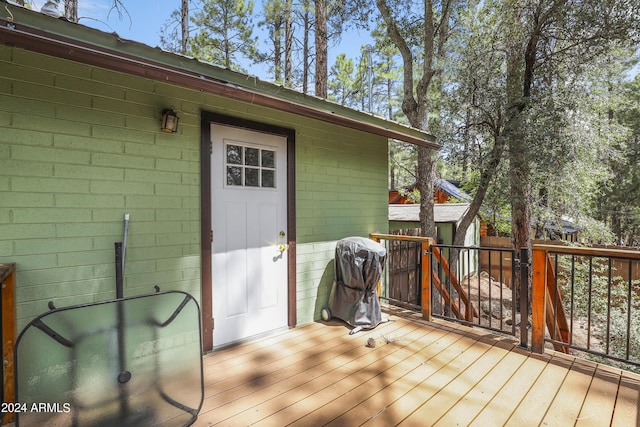 wooden deck featuring an outbuilding and a shed