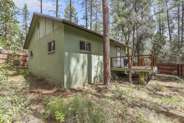 view of side of property with fence and a deck