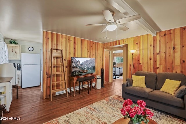 living area with beam ceiling, dark wood finished floors, wood walls, and ceiling fan