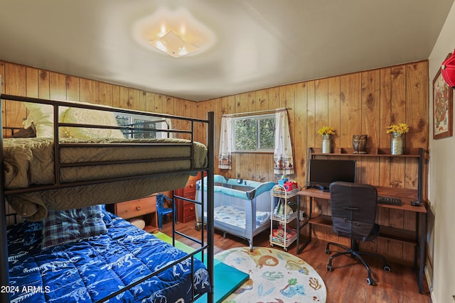 bedroom featuring wooden walls and wood finished floors