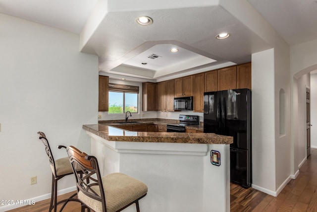 13600 N Fountain Hills Blvd Unit 501, Fountain Hills, AZ 85268 - kitchen with black appliances, arched walkways, dark wood-type flooring, tile countertops, and a raised ceiling