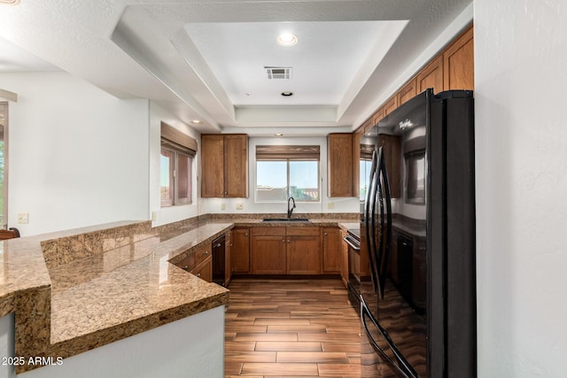 13600 N Fountain Hills Blvd Unit 501, Fountain Hills, AZ 85268 - kitchen featuring black appliances, brown cabinets, dark wood-style flooring, a raised ceiling, and recessed lighting