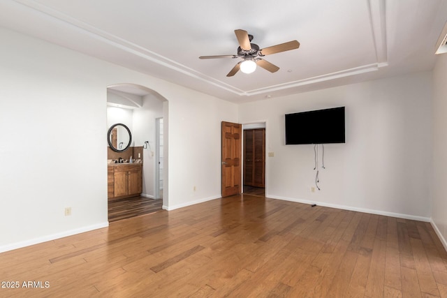 13600 N Fountain Hills Blvd Unit 501, Fountain Hills, AZ 85268 - unfurnished living room featuring arched walkways, a tray ceiling, a ceiling fan, and hardwood / wood-style flooring