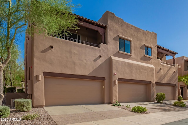 13600 N Fountain Hills Blvd Unit 501, Fountain Hills, AZ 85268 - pueblo revival-style home featuring an attached garage, stucco siding, concrete driveway, and a balcony