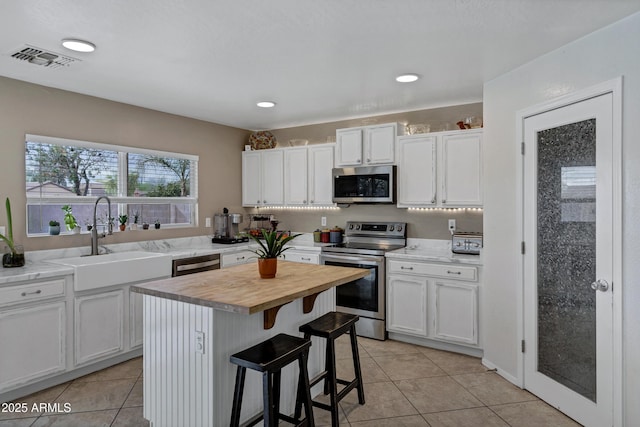 28014 N Jade St, San Tan Valley, AZ 85143 - kitchen featuring white cabinets, visible vents, stainless steel appliances, butcher block counters, and a sink
