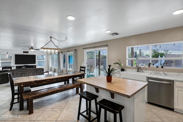 28014 N Jade St, San Tan Valley, AZ 85143 - kitchen featuring light tile patterned floors, stainless steel dishwasher, a sink, butcher block counters, and visible vents
