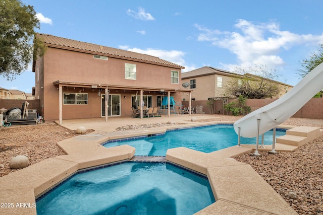 28014 N Jade St, San Tan Valley, AZ 85143 - view of swimming pool with a fenced backyard, a pool with connected hot tub, a water slide, and a patio area