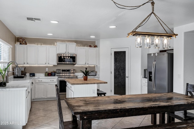 28014 N Jade St, San Tan Valley, AZ 85143 - kitchen with white cabinetry, visible vents, a center island, and appliances with stainless steel finishes