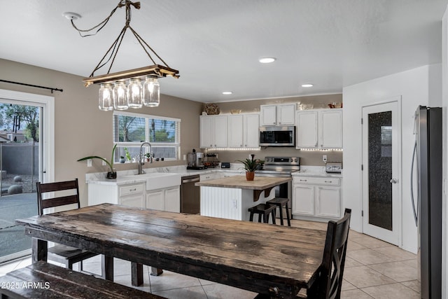 28014 N Jade St, San Tan Valley, AZ 85143 - kitchen featuring butcher block countertops, plenty of natural light, a sink, white cabinets, and appliances with stainless steel finishes