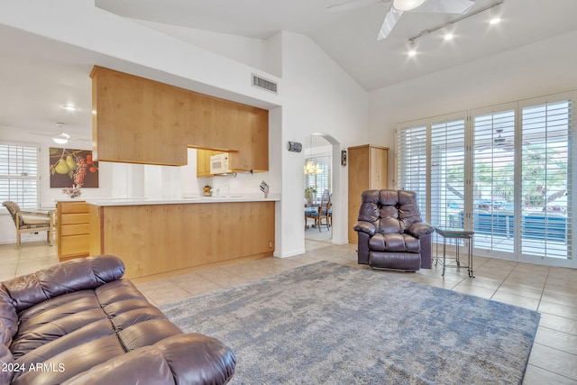 living room with ceiling fan, high vaulted ceiling, and light tile patterned floors