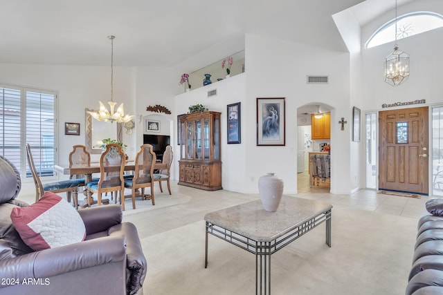 tiled living room featuring a chandelier and high vaulted ceiling