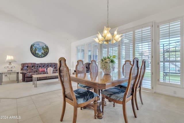 dining room with vaulted ceiling, light tile patterned flooring, an inviting chandelier, and plenty of natural light